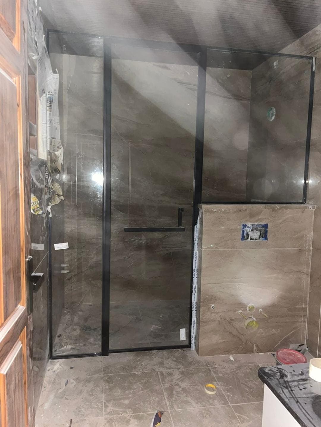Wall-to-wall frameless shower screen in clear toughened glass