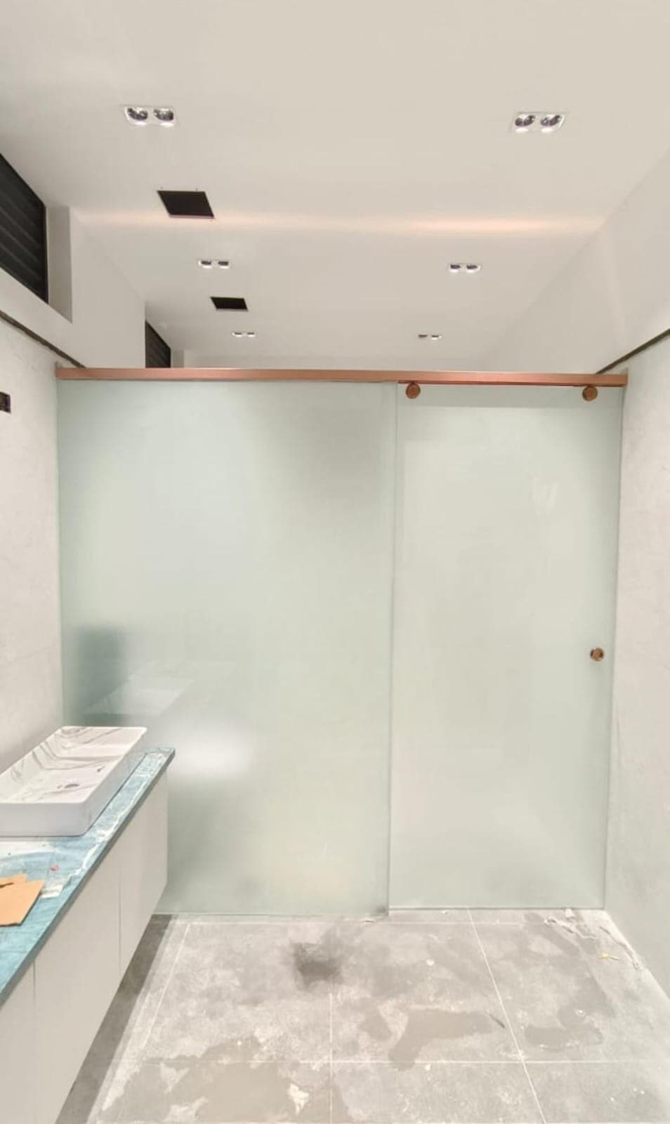 Wall-to-wall frameless shower screen in clear toughened glass