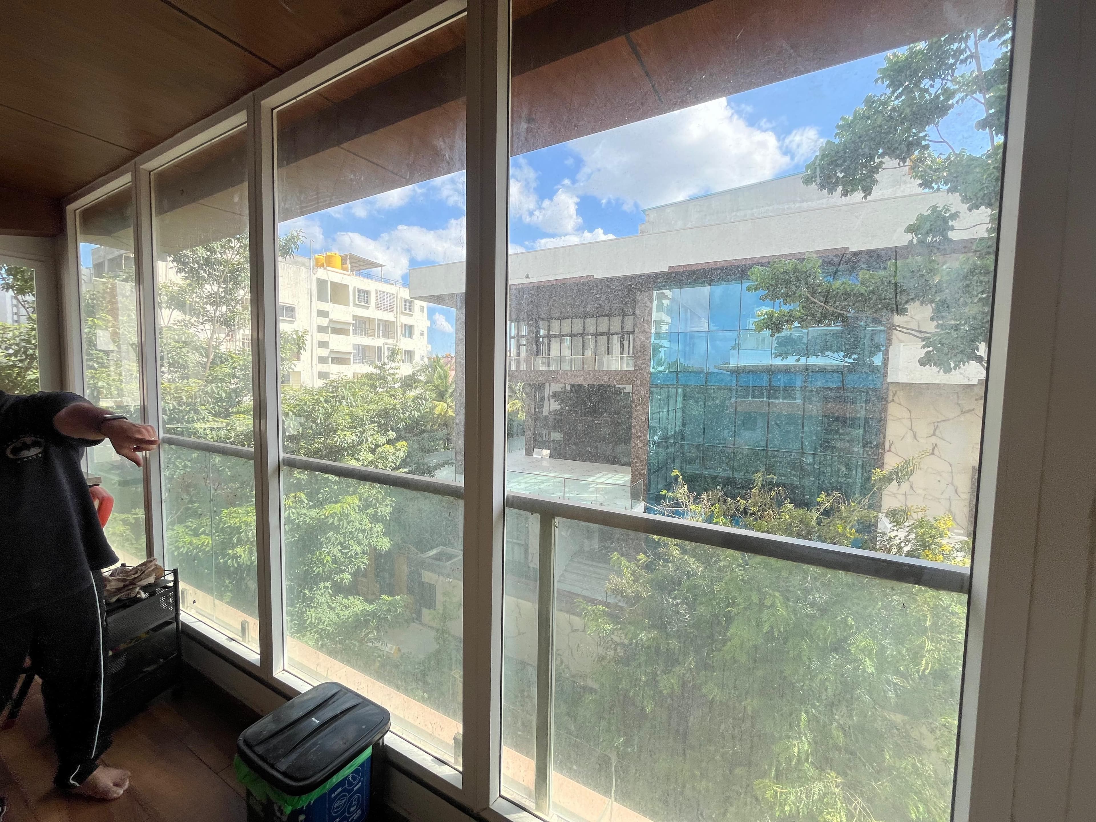 A wall of aluminium framed glass windows along an upstairs balcony corridor